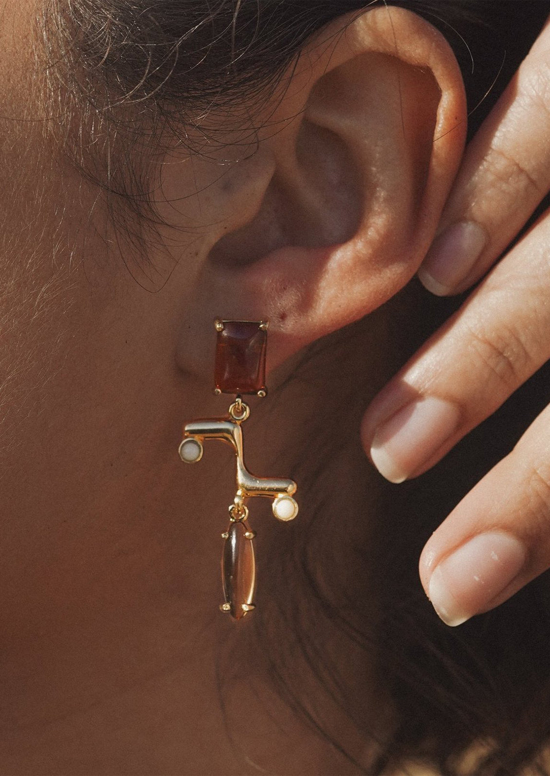 A pair of drop earrings with colored cabochons.