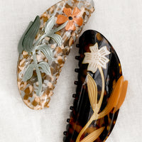 1: Large acetate hair claws with floral patterns.