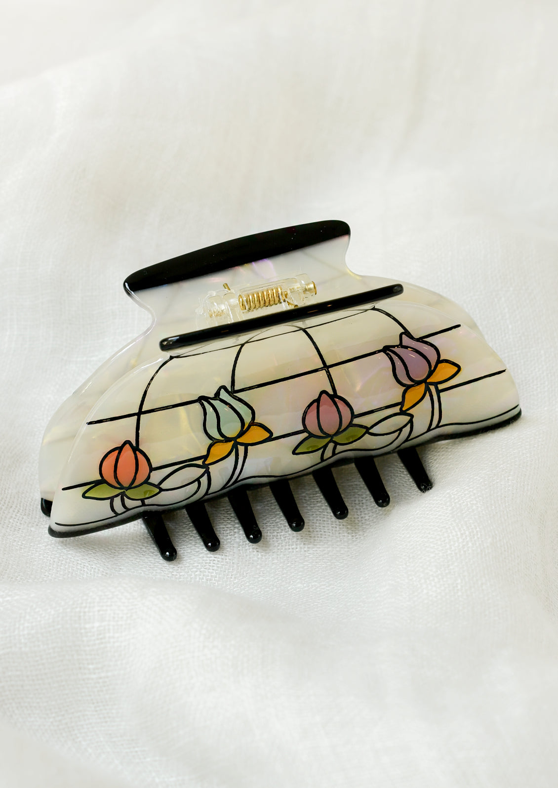 A hair claw shaped like a lamp shade with colorful florals and a grid pattern.