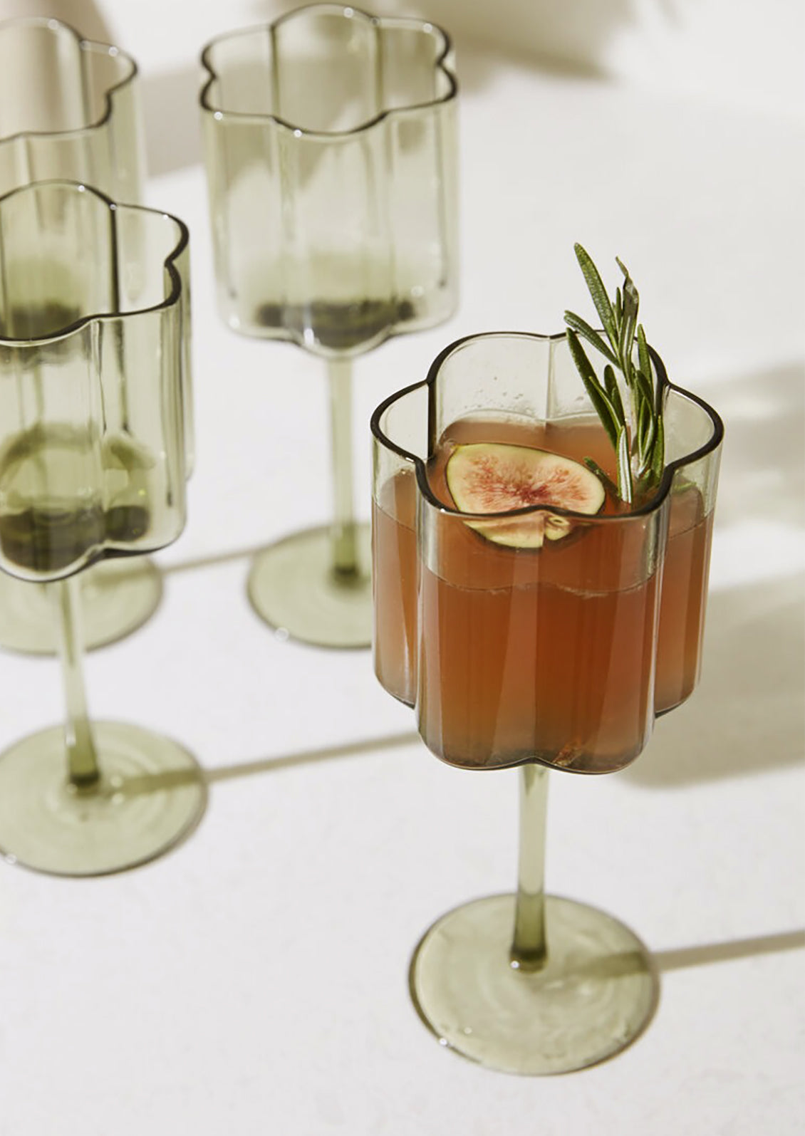 Flower shaped stemmed wine glasses in natural recycled glass.