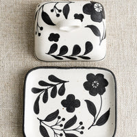 1: A black and white floral print butter dish.