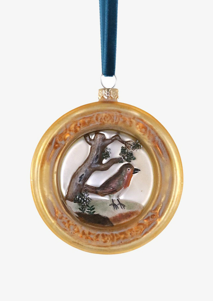 1: A glass ornament of a robin in gold frame.