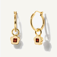 1: A pair of gold hoop earrings with garnet flower charm.
