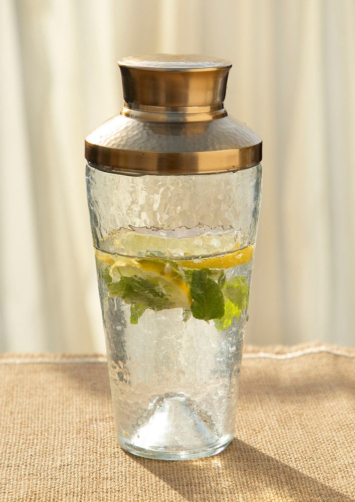 A hammered glass cocktail shaker.