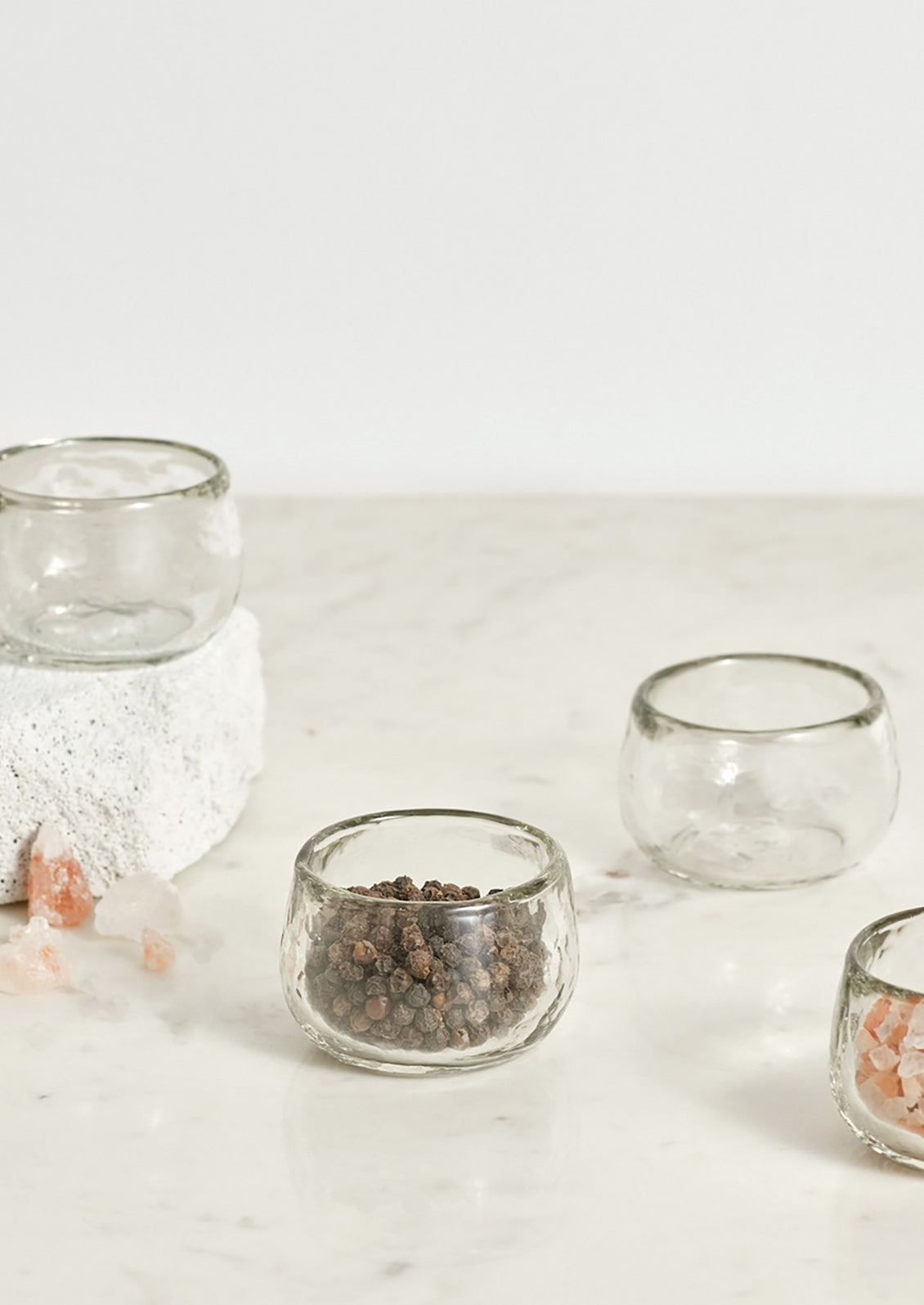 Small glass bowls holding salt and pepper.