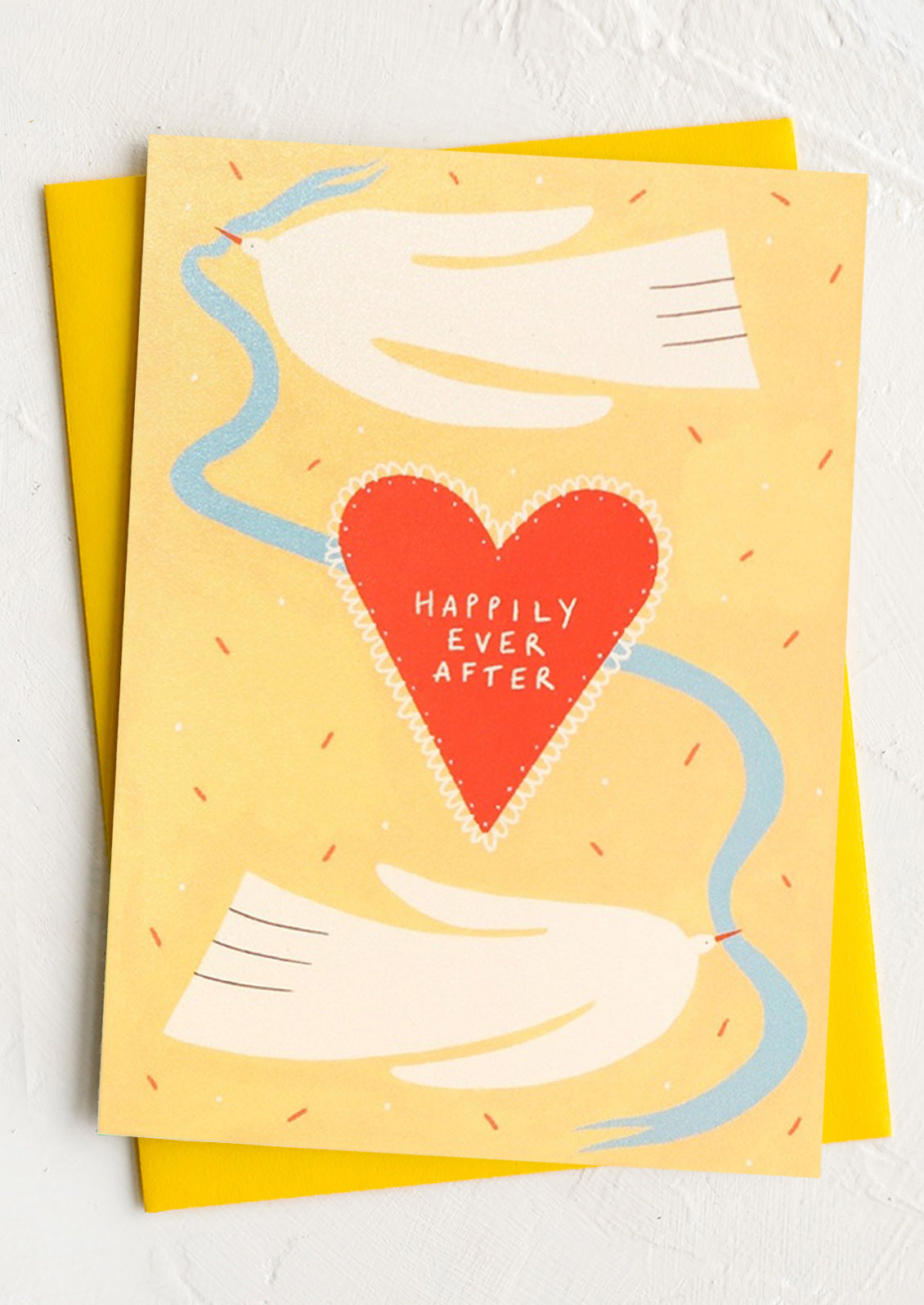 Card with a red heart and 'Happily Ever After' text on a yellow background