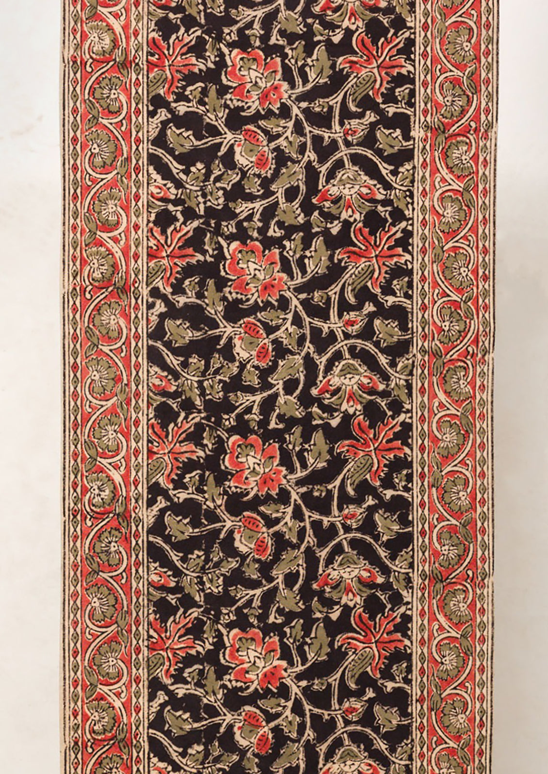 A table runner with black and red floral print.