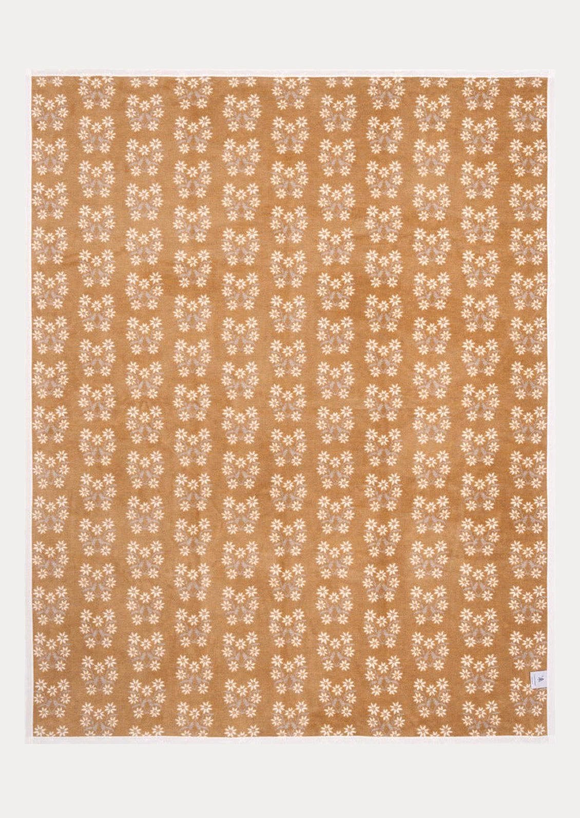 Patterned blanket with a repetitive floral design on a beige background