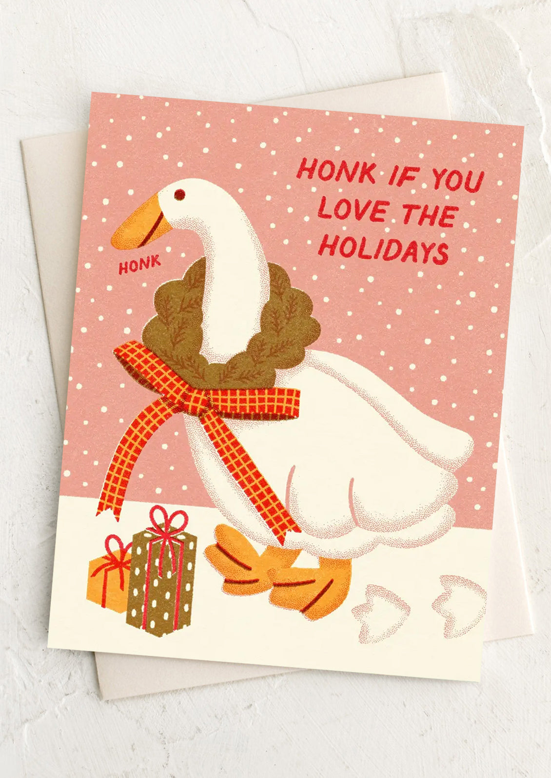 A greeting card with cartoon-like image of a goose, text reads "Honk if you love the holidays".