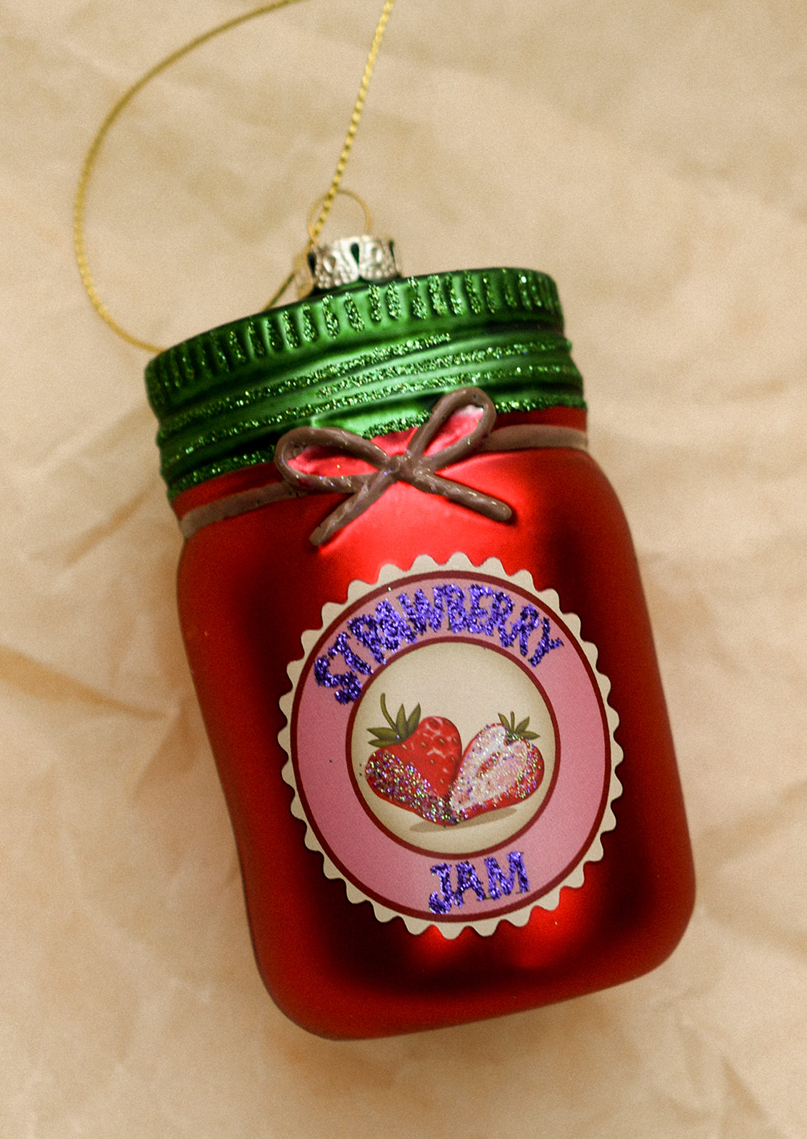 A glass ornament resembling a jar of strawberry jam.