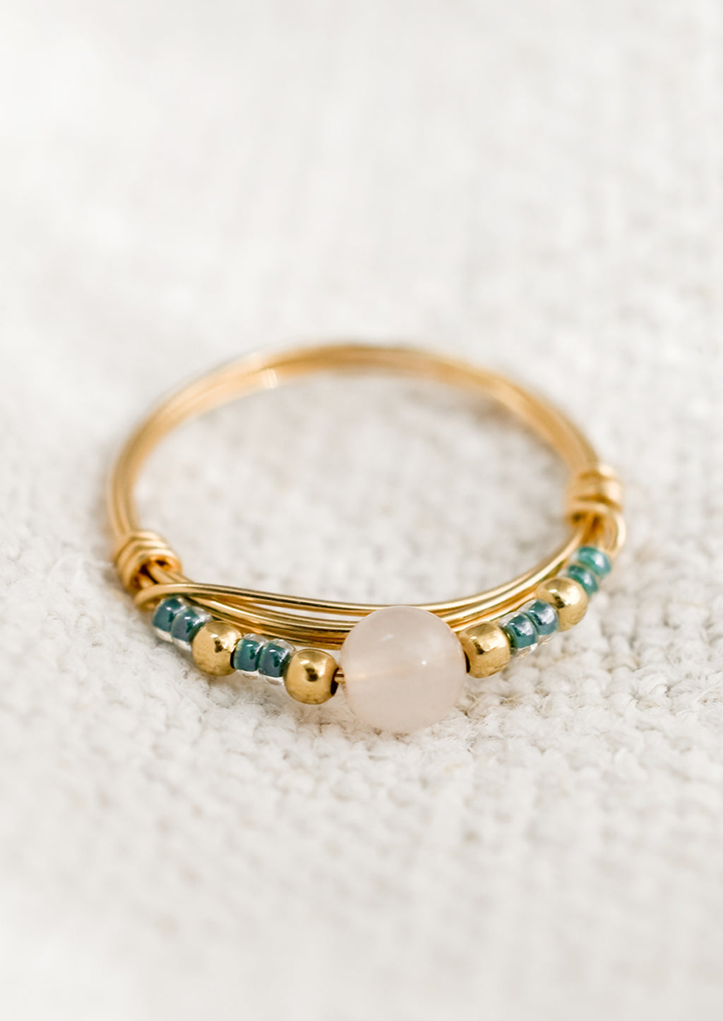 1: A gold wire ring with blue and pink beads.