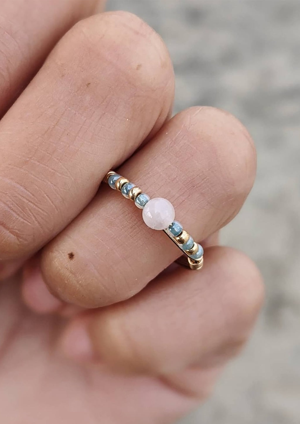 2: A gold wire ring with blue and pink beads.