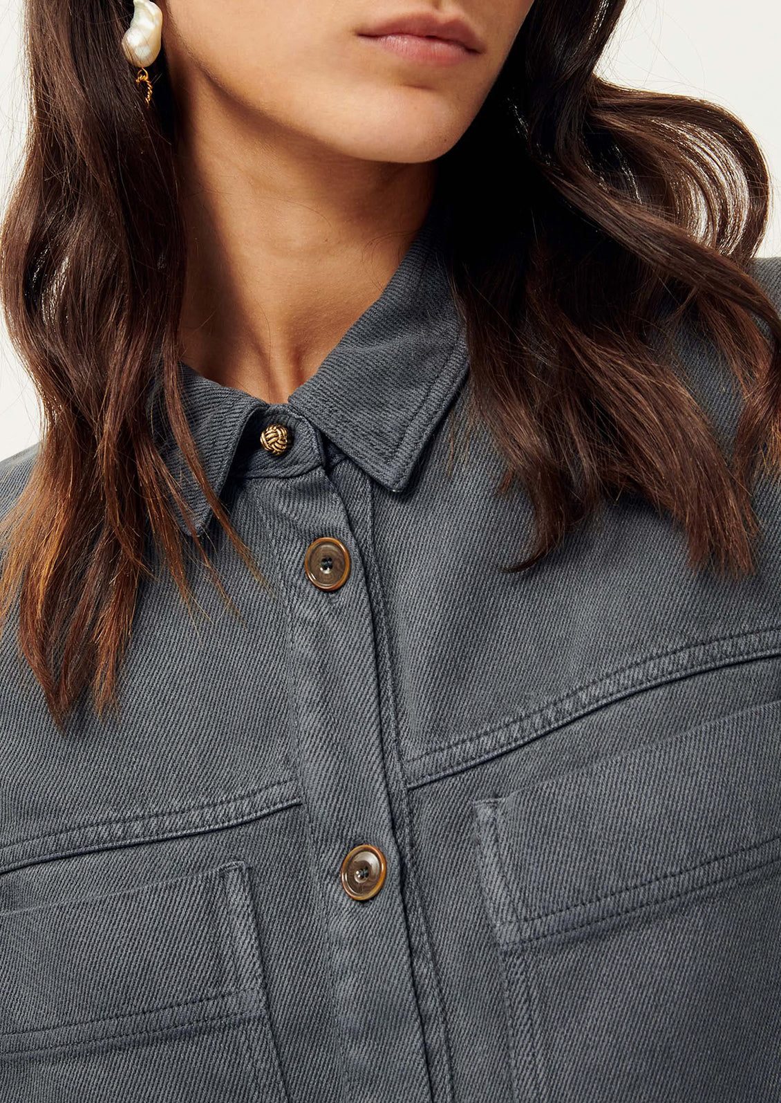 Close-up of woman wearing dark gray shirt jacket.