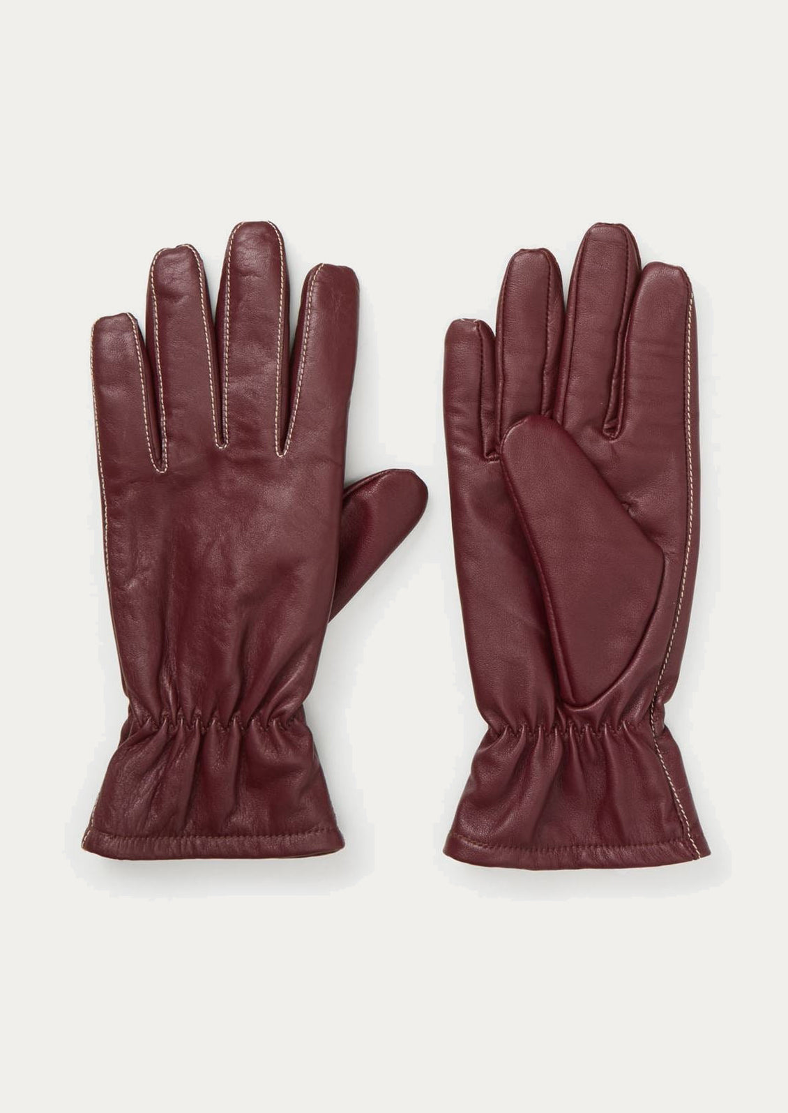 Pair of burgundy leather gloves on a light gray background