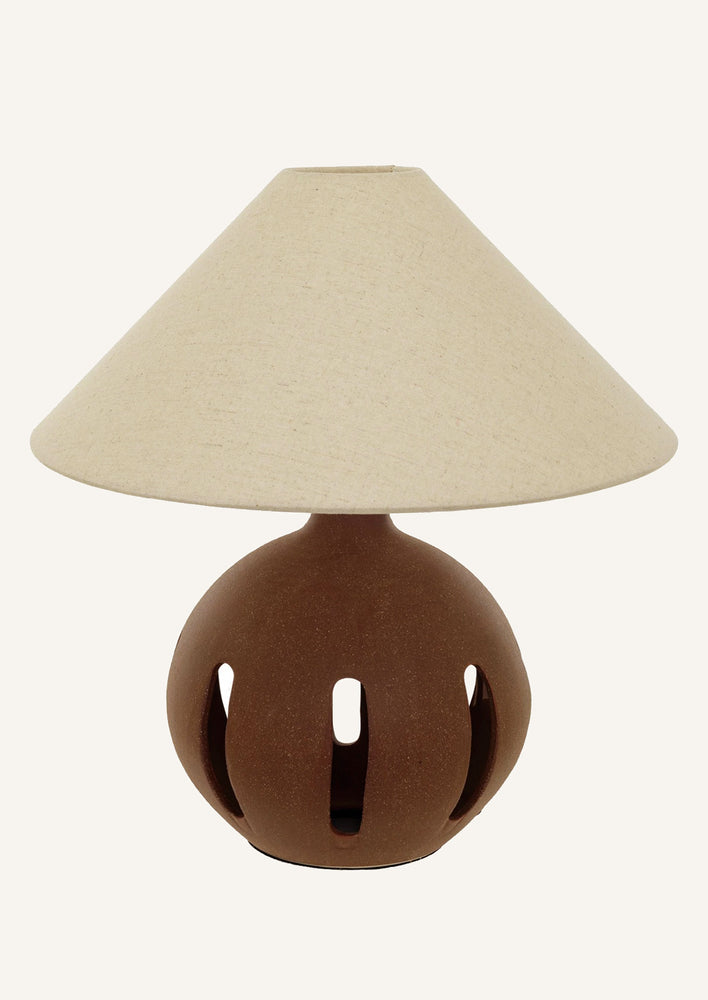 1: A table lamp with brown ceramic base with slit-shaped cutouts.