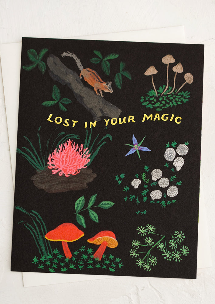 A card with woodland flora and fauna print, text reads "Lost in your magic".