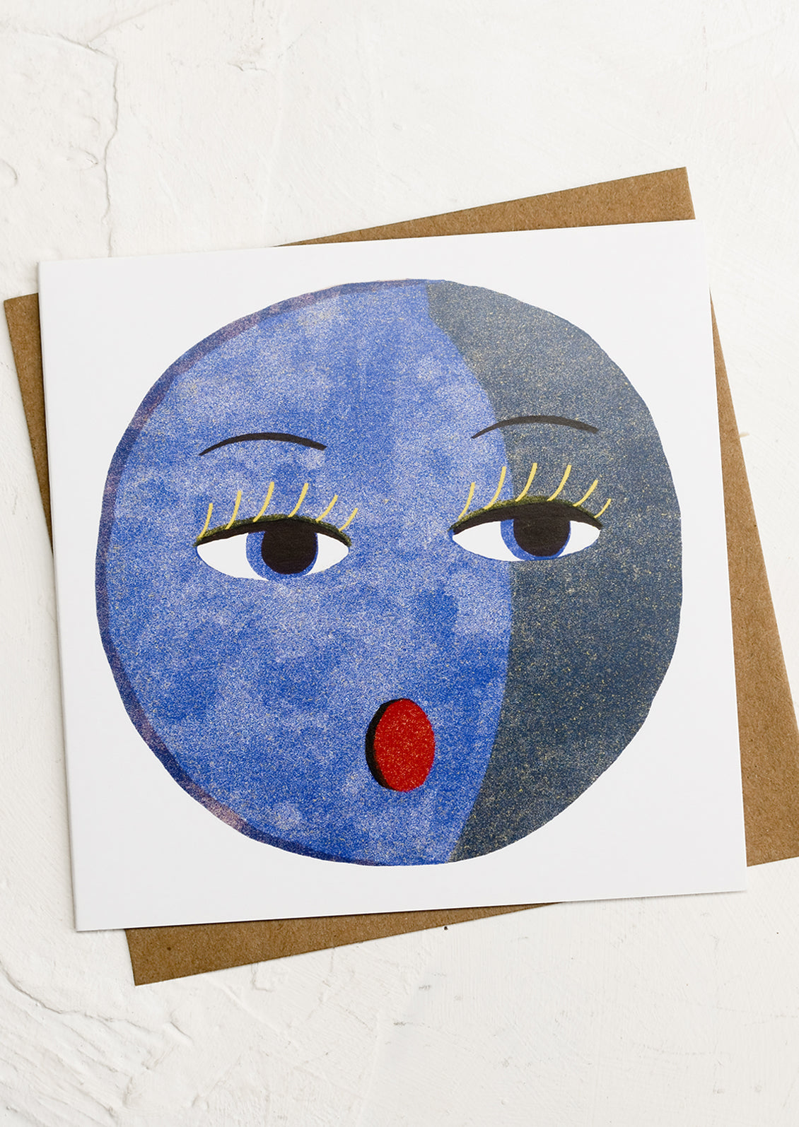 A square greeting card with illustration of blue moon with face.