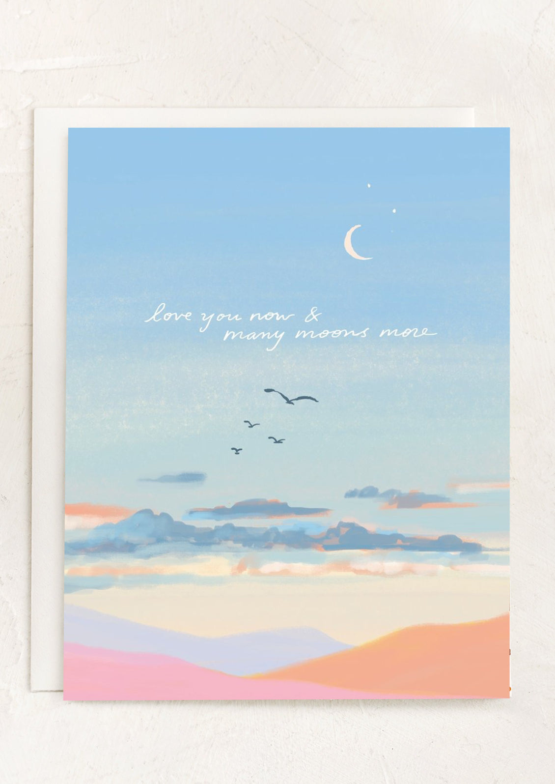 An illustrated card of sunset and clouds, text reads "Love you now & many moons more".