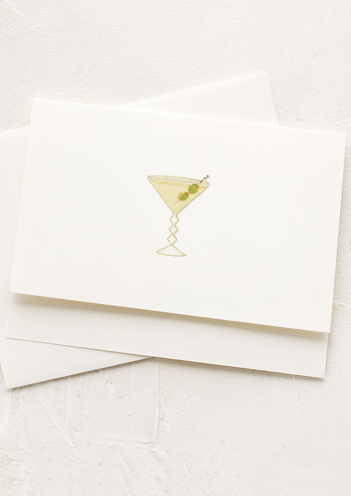 White card with a gold foil martini illustration on a white background