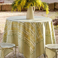 1: A block printed botanical patterned tablecloth in pastel yellow and green tones.