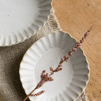 1: Pleated stoneware dishes in assorted shapes.