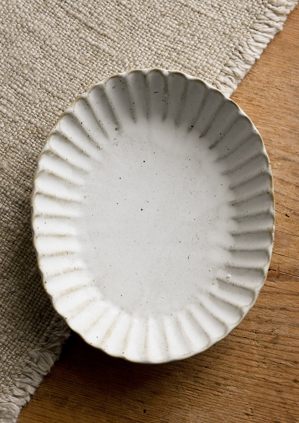 Oval: A pleated stoneware dish in oval shape.
