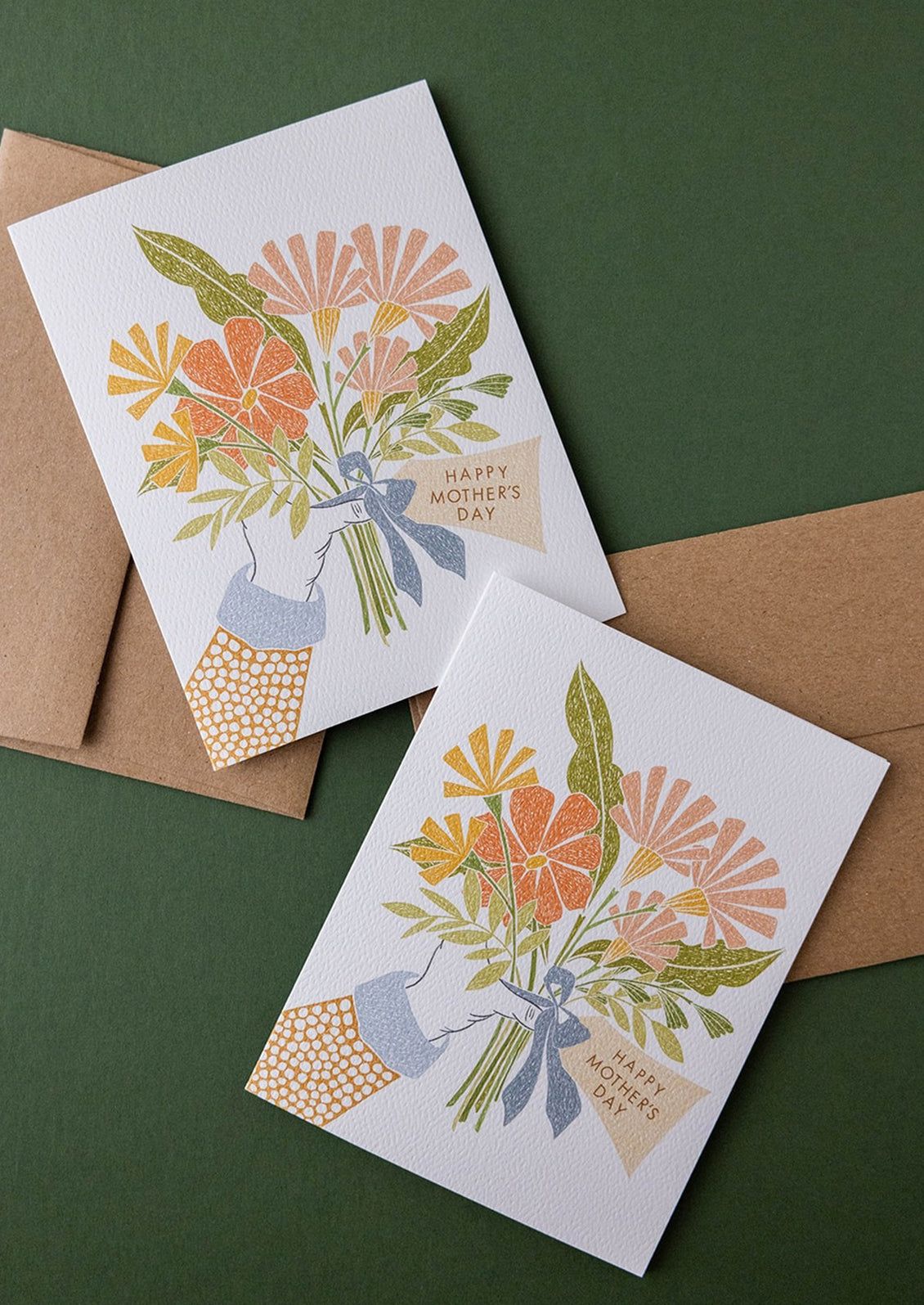 A card with illustration of hand holding bouquet of flowers, text reads "Happy Mother's Day".