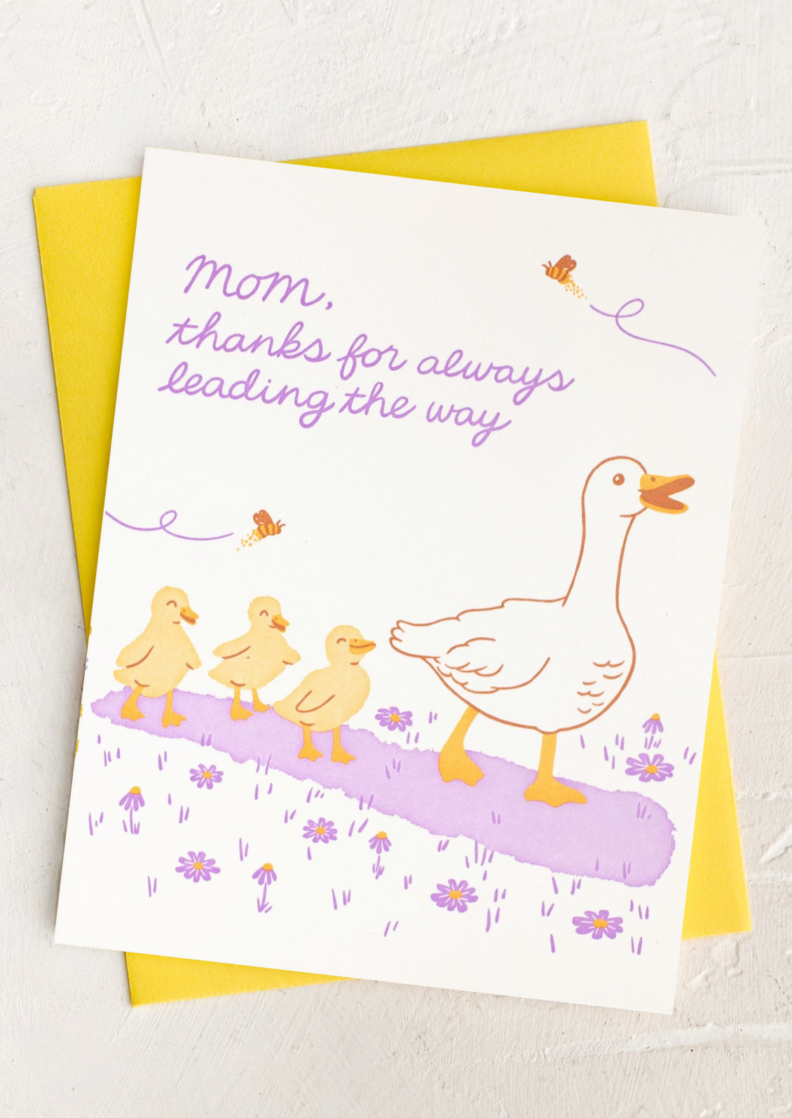 Greeting card with illustration of a goose and her chicks and text 'Mom, thanks for always leading the way' on a yellow envelope.