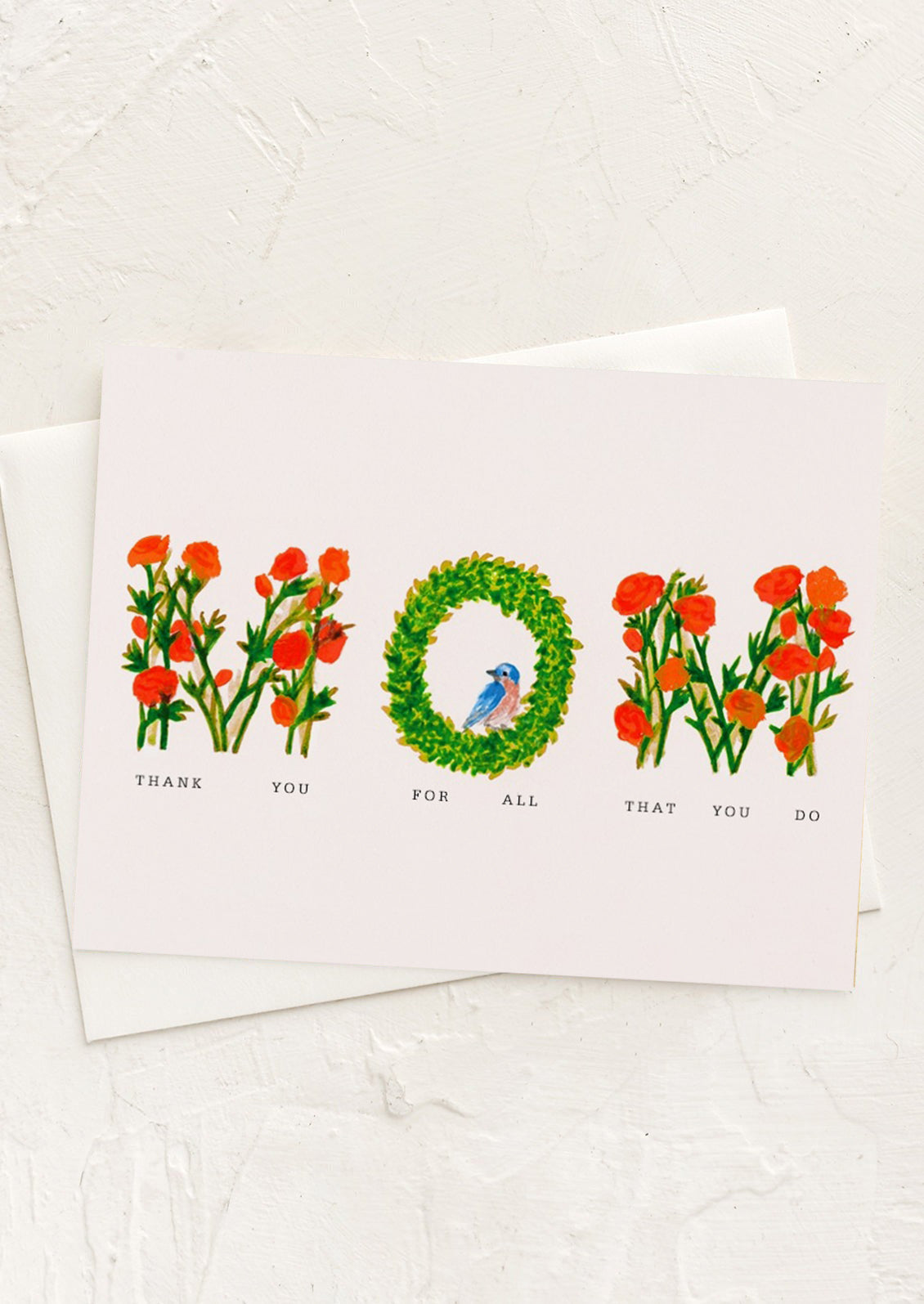 A card with botanical lettering spelling "MOM", text underneath reads "Thank you for all that you do".