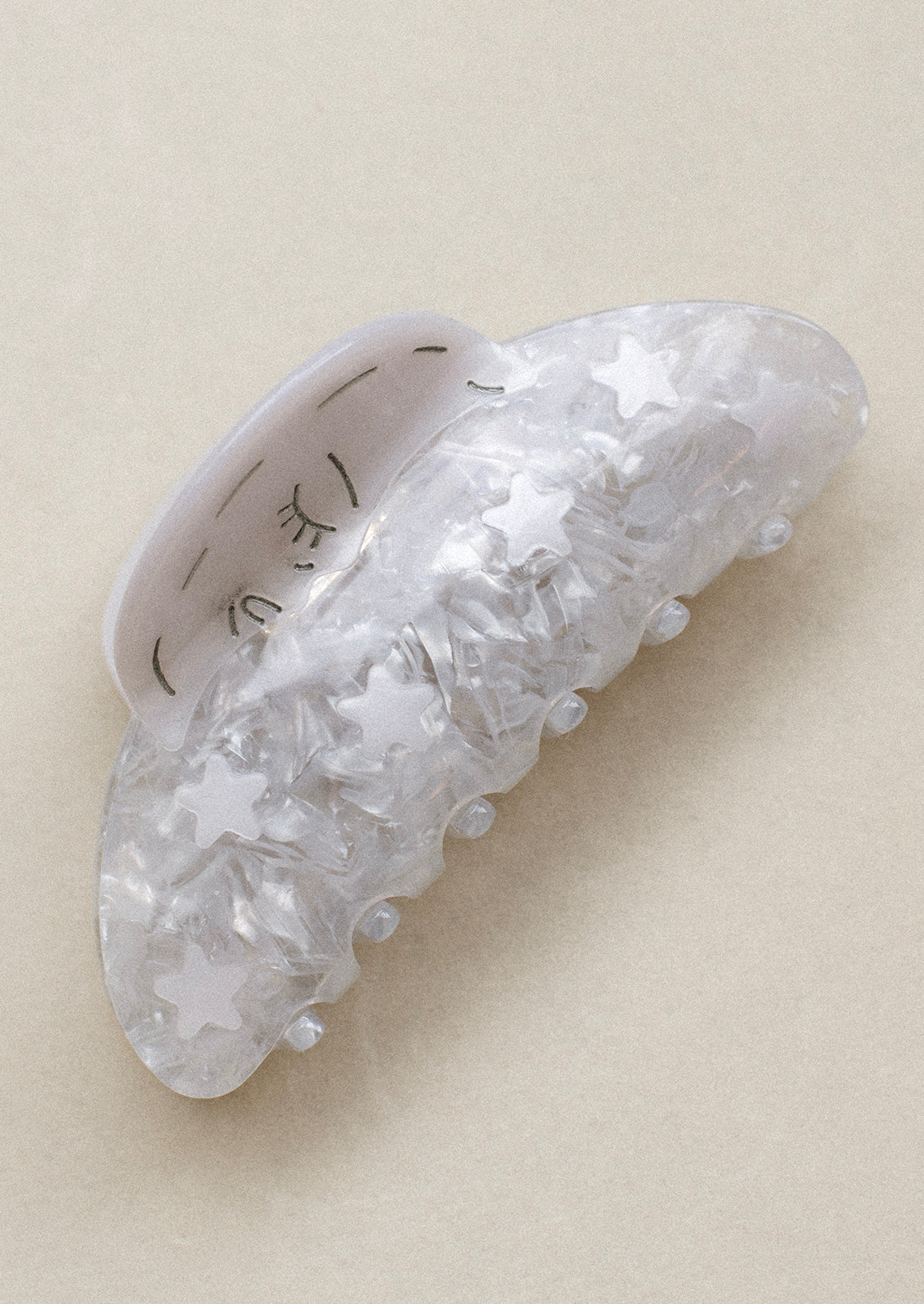 A silver hair claw with moon and stars pattern.