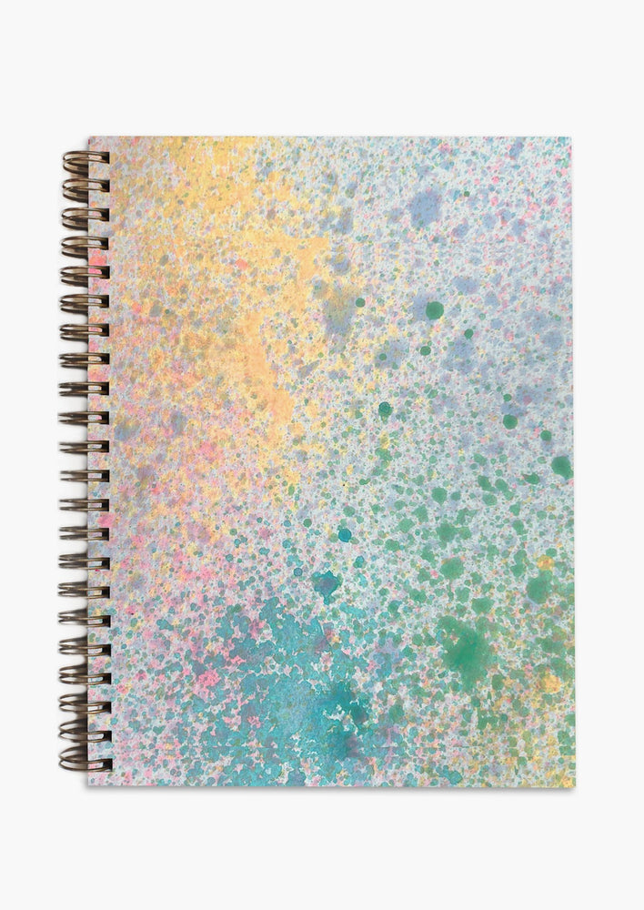 A colorful splatter pattern spiral bound notebook.