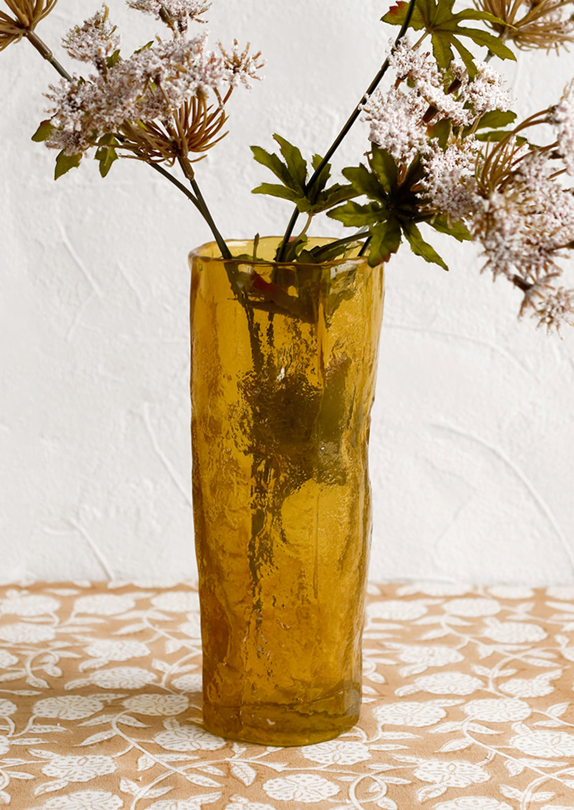 An amber glass vase with irregular texture and shape.