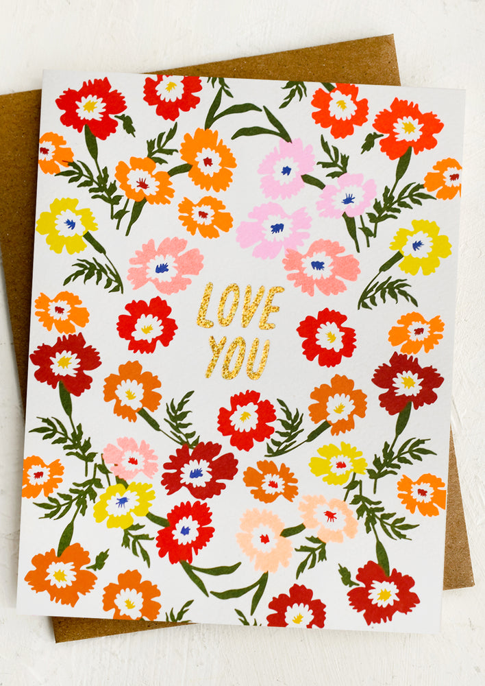 A dianthus print card in bright colors with gold text reading "LOVE YOU".