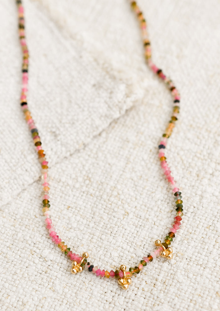 1: A multicolor tourmaline necklace on neon pink string.