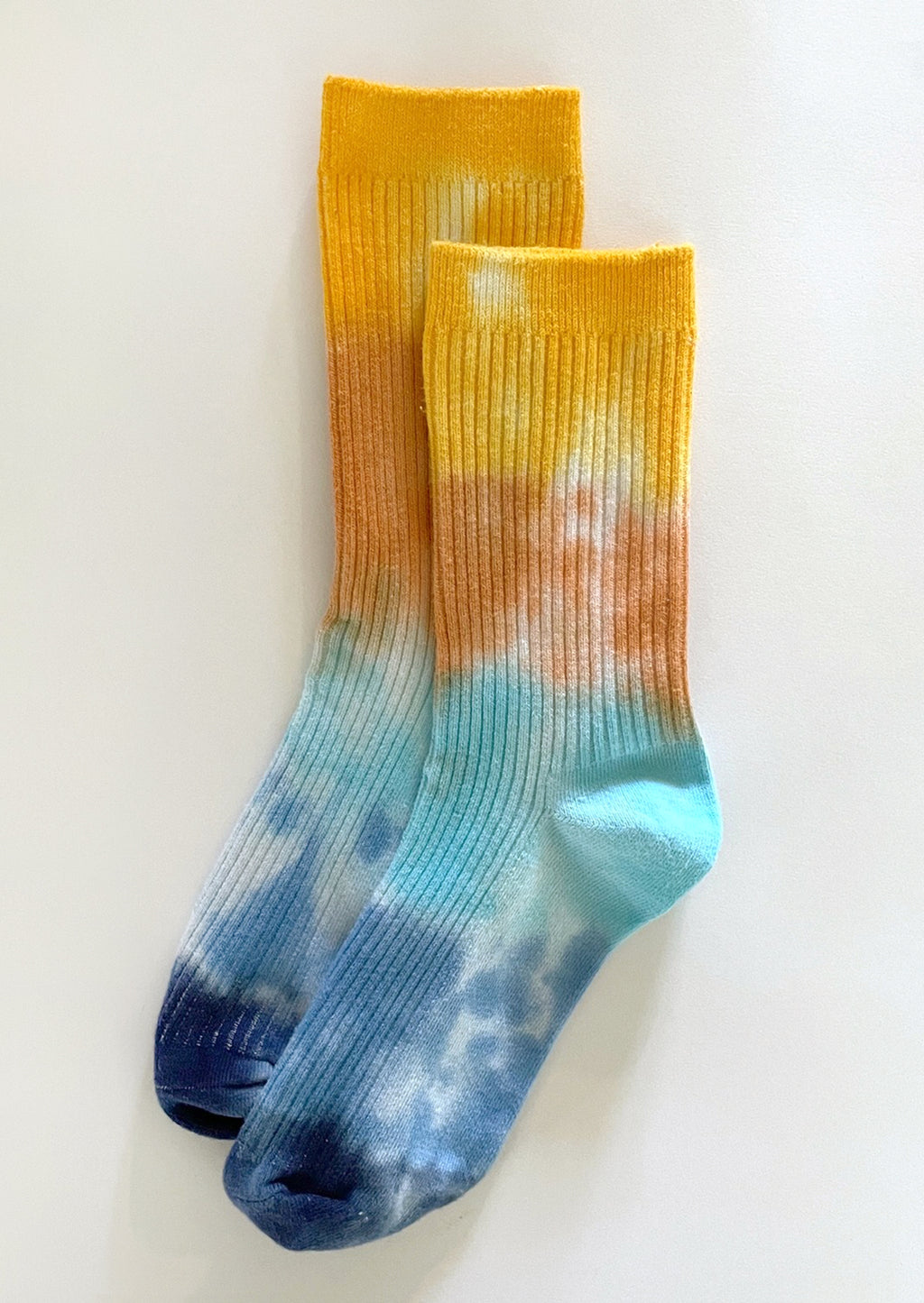 Ocean Avenue: A pair of tie dye socks in yellow, orange and blue.