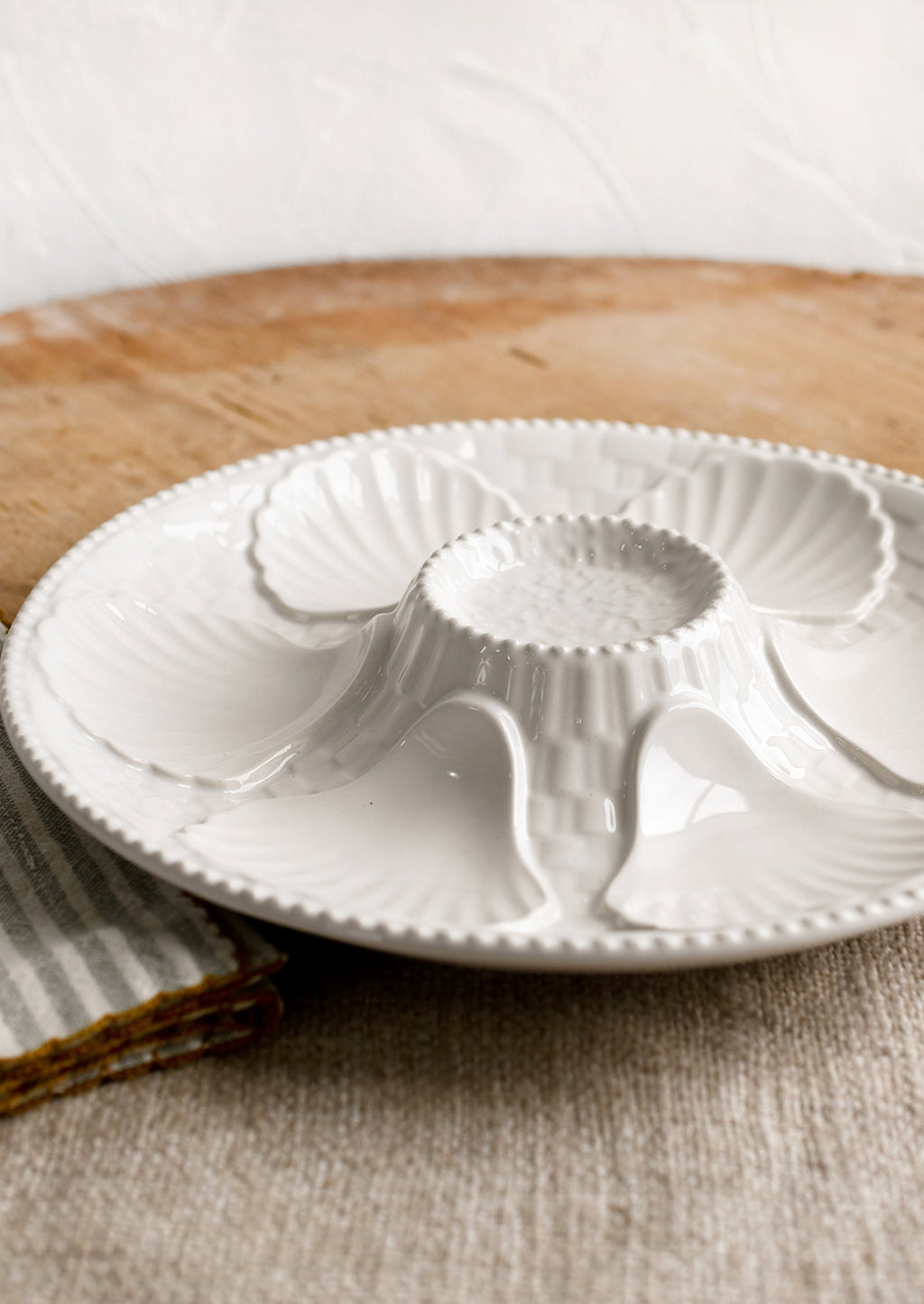 3: A glossy white ceramic plate with shell design.