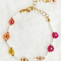 Fuchsia Multi: A white beaded bracelet with pink and yellow beaded flowers.