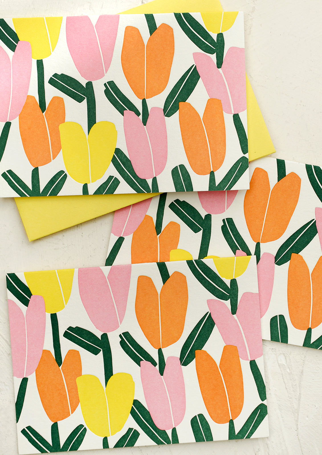 Cards with pink, orange and yellow letterpress tulip pattern.