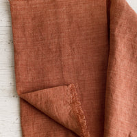 Paprika: A linen table runner with frayed edges in paprika.