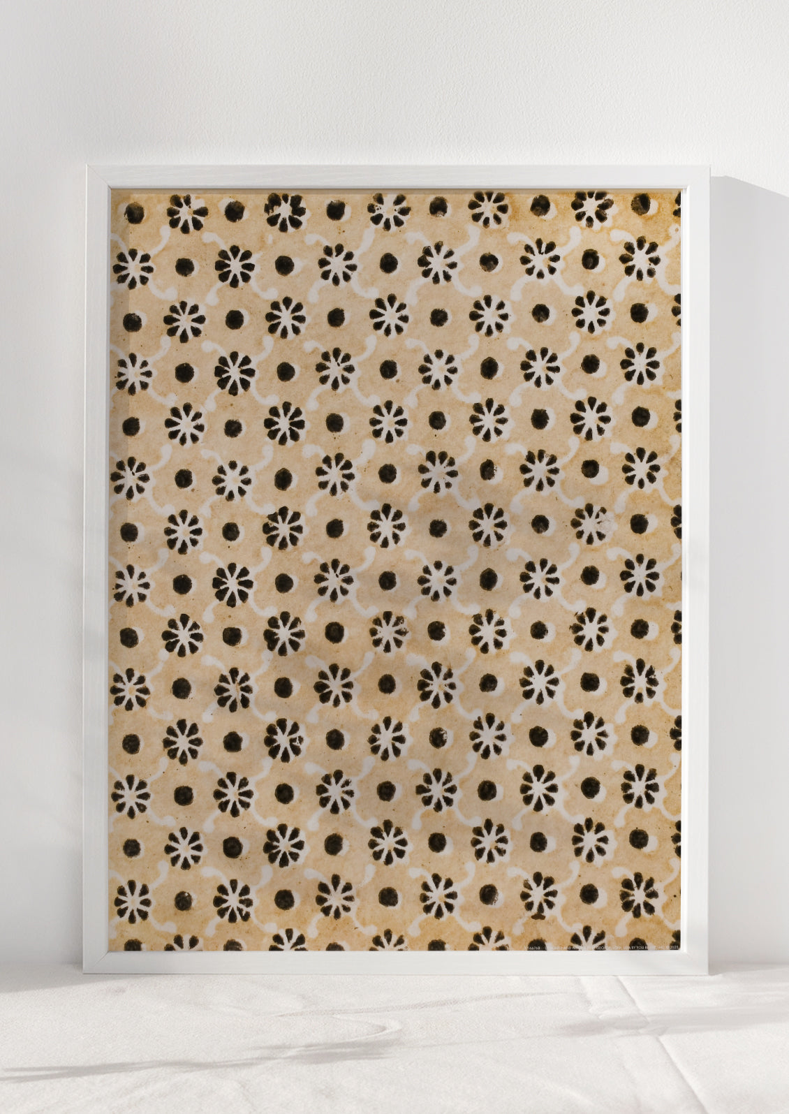 A textile inspired art print in white frame.