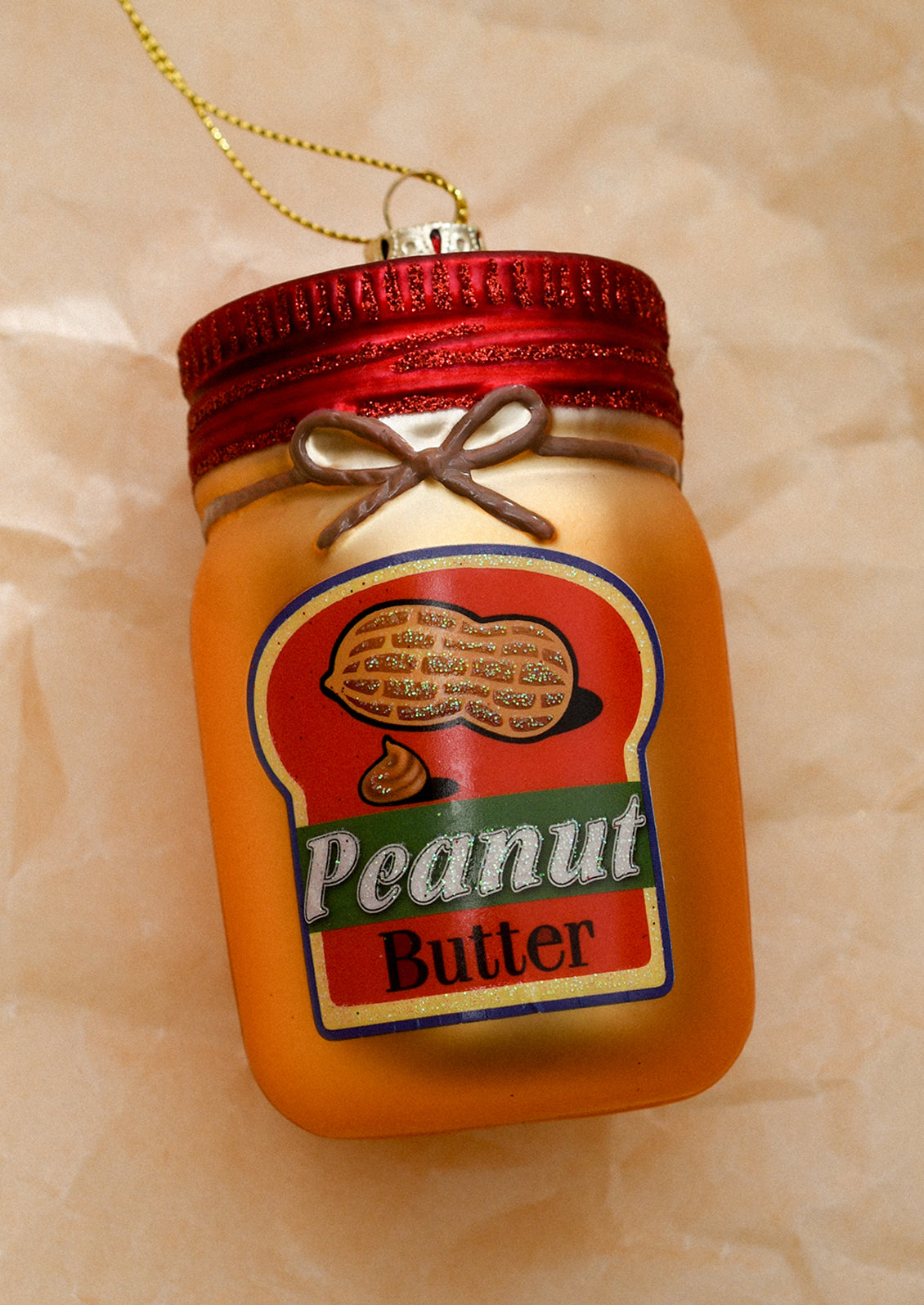 A glass ornament resembling a jar of peanut butter.