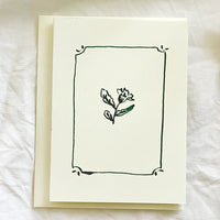 1: A card with framed floral illustration in green ink.