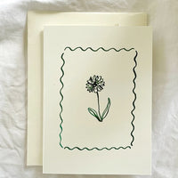 2: A card with framed floral illustration in green ink.