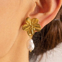 2: A pair of earrings with flower shaped post and dangling pearl bead.