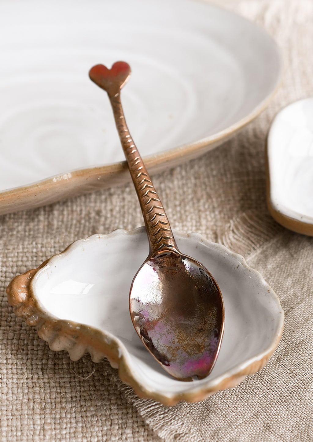 Spoon: A copper spoon with fish-tail handle.