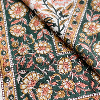 2: A block printed floral tablecloth in peach, brown and emerald.