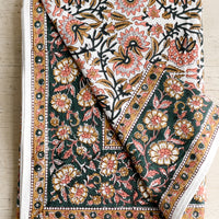 1: A block printed floral tablecloth in peach, brown and emerald.