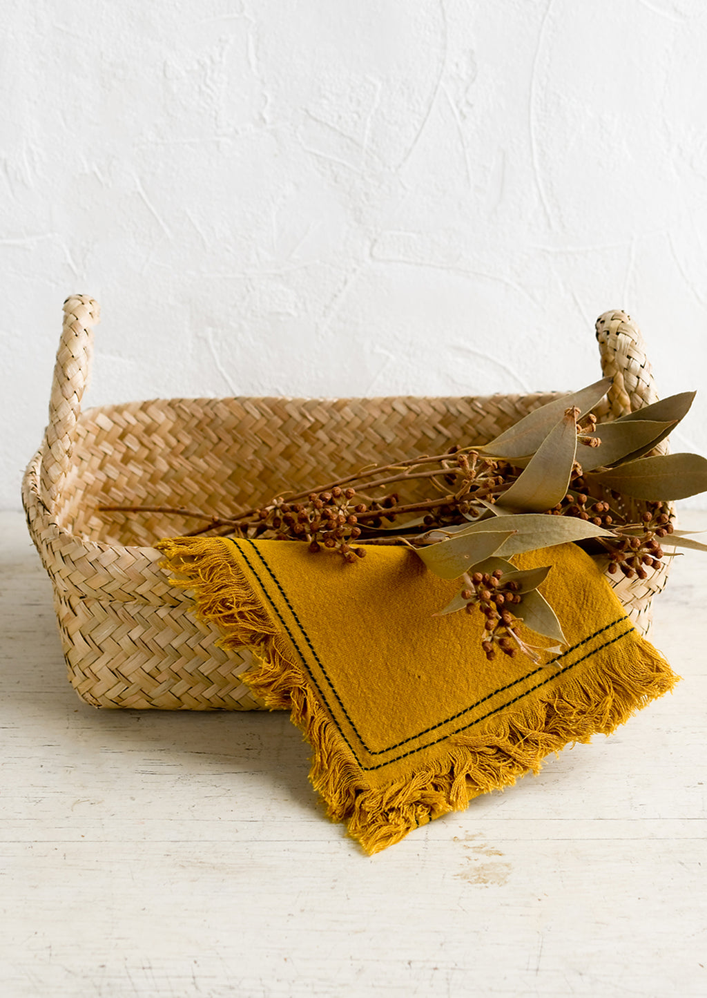 2: A rectangular seagrass basket with rolled top rim and side handles.