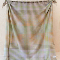1: A gingham check print throw in mix of pastel and earthy greens and browns.