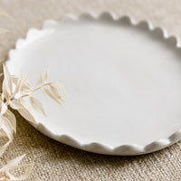 2: A white ceramic oval tray with scalloped edges.